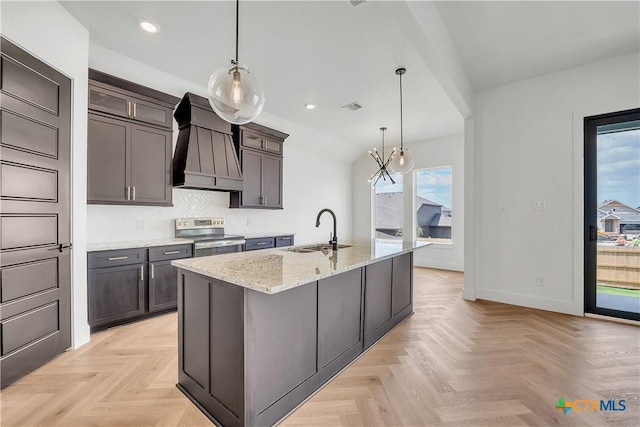 kitchen featuring sink, premium range hood, dark brown cabinets, light stone counters, and stainless steel electric range oven