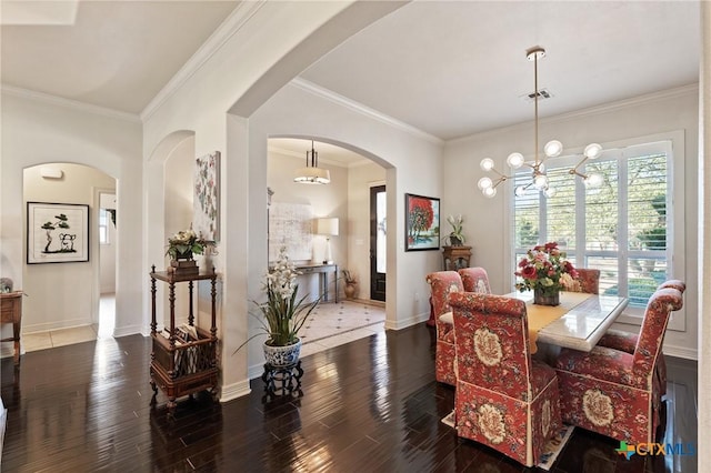 dining area with a notable chandelier, wood finished floors, visible vents, baseboards, and ornamental molding