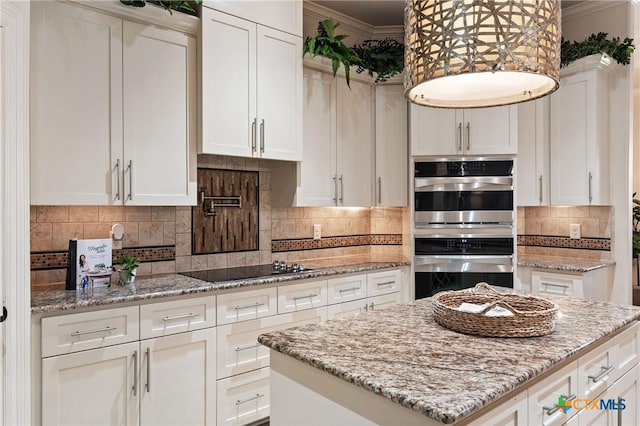 kitchen featuring double oven, white cabinets, ornamental molding, and black electric stovetop