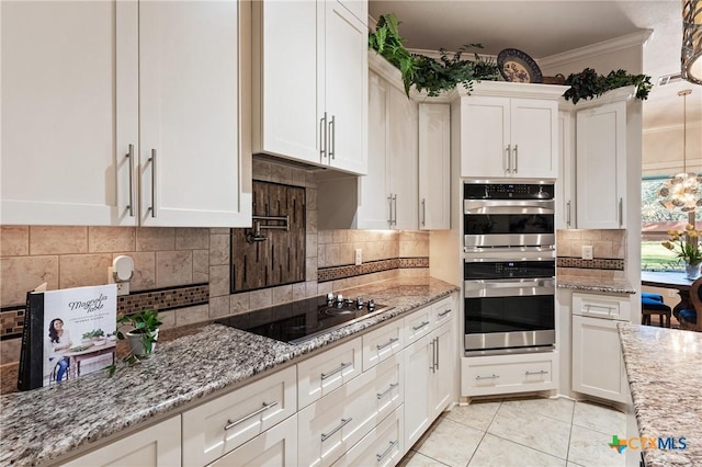 kitchen featuring black electric stovetop, stainless steel double oven, white cabinetry, ornamental molding, and decorative backsplash