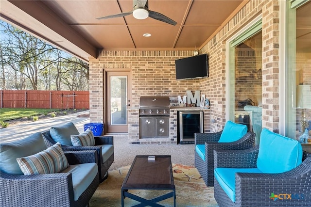 view of patio with an outdoor kitchen, outdoor lounge area, fence, and a grill