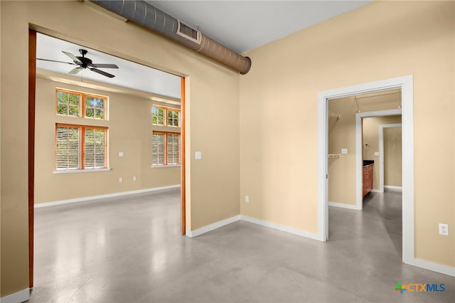 spare room featuring ceiling fan and concrete floors