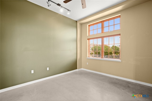 unfurnished room featuring concrete flooring, ceiling fan, and track lighting