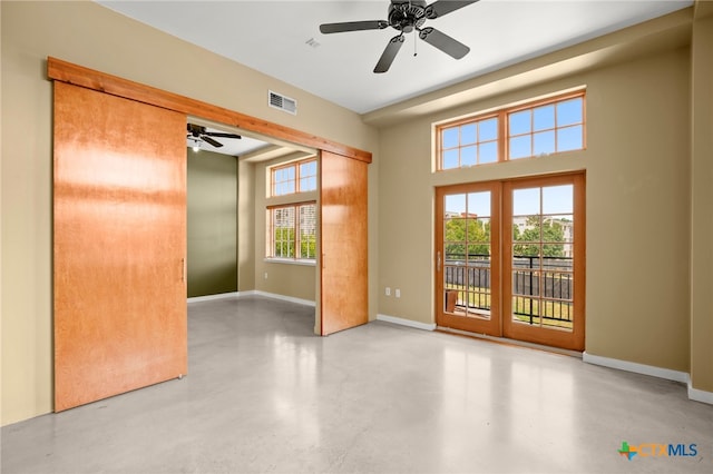 empty room featuring ceiling fan and plenty of natural light