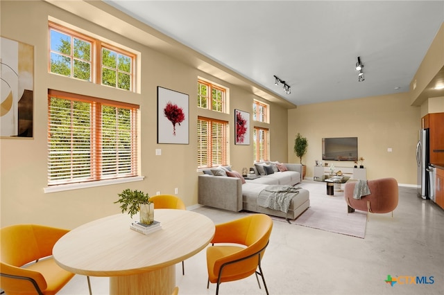 living room with concrete flooring and track lighting