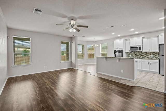 5712 Stonehaven Dr, Temple, TX 76502 - kitchen featuring stainless steel appliances, a ceiling fan, open floor plan, a chandelier, and light wood finished floors