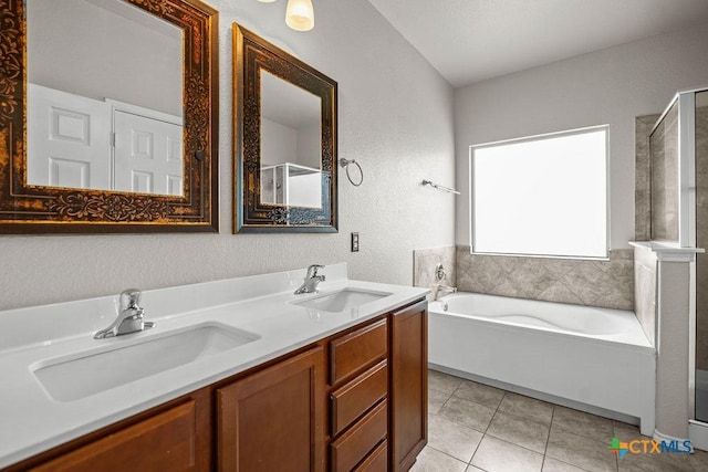 5712 Stonehaven Dr, Temple, TX 76502 - bathroom featuring a shower with shower door, a garden tub, double vanity, a textured wall, and tile patterned flooring