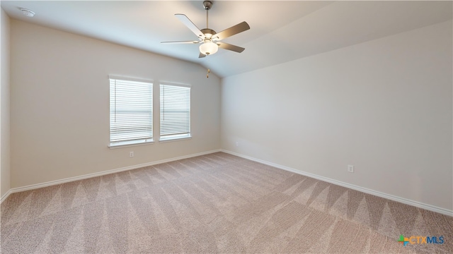 spare room featuring ceiling fan, light colored carpet, and lofted ceiling