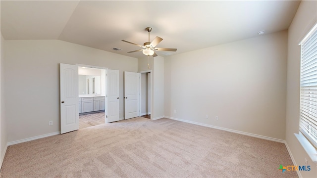 unfurnished bedroom featuring ceiling fan, light colored carpet, lofted ceiling, and multiple windows