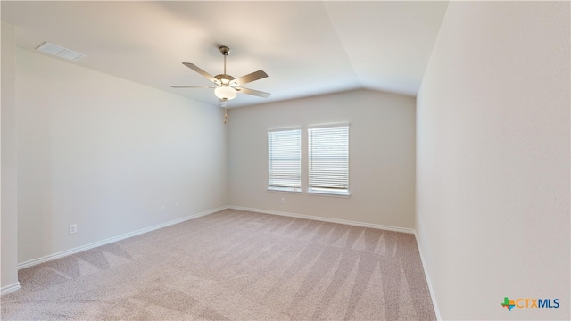 empty room featuring light colored carpet, vaulted ceiling, and ceiling fan