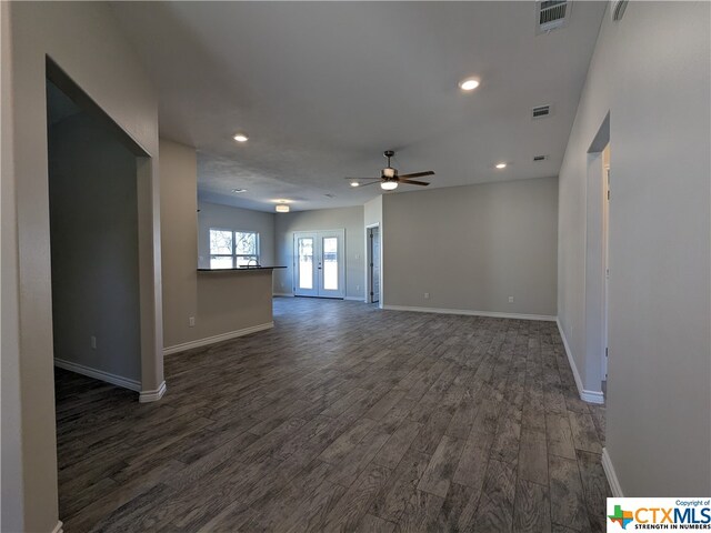 unfurnished living room with french doors, dark wood-type flooring, and ceiling fan