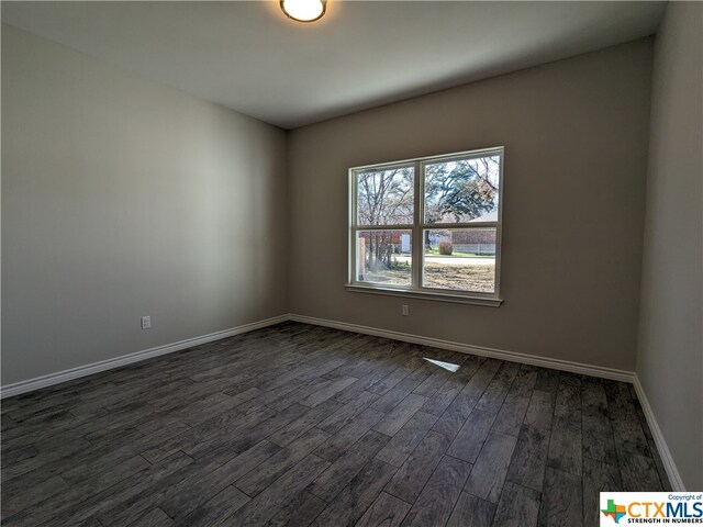 spare room with dark wood-type flooring