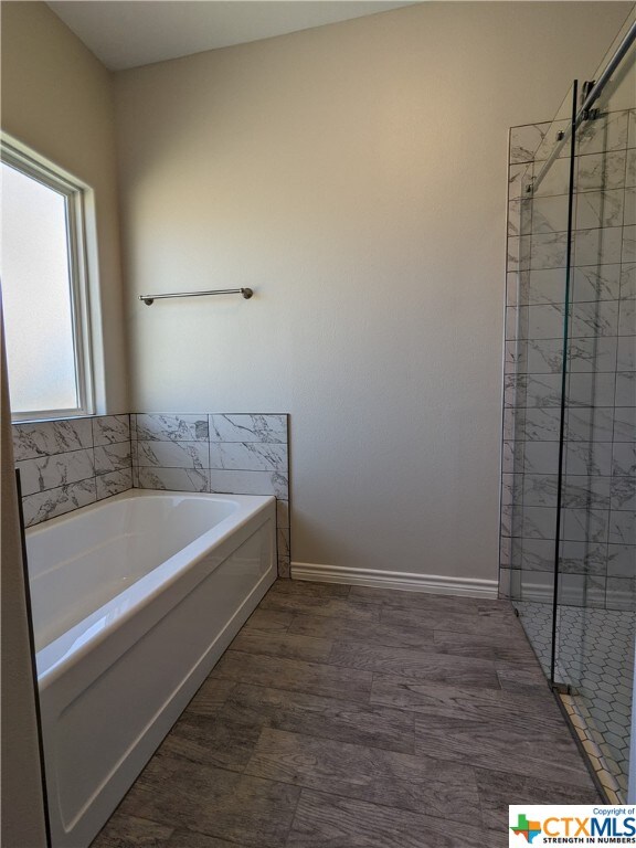 bathroom with plus walk in shower and hardwood / wood-style floors