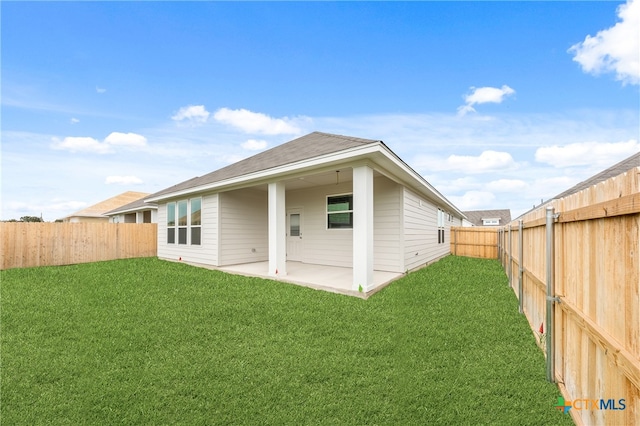 back of house with a lawn and a patio area