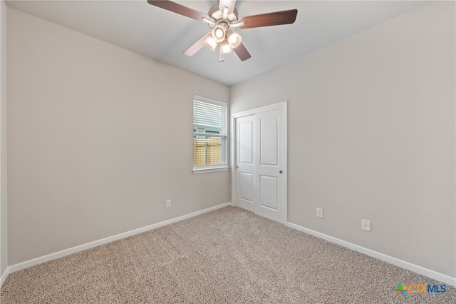 carpeted spare room with ceiling fan