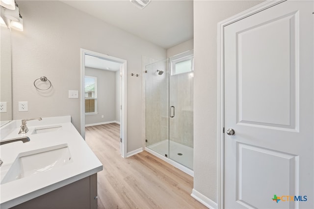 bathroom with walk in shower, hardwood / wood-style floors, a wealth of natural light, and vanity