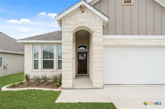 entrance to property featuring a garage and a yard