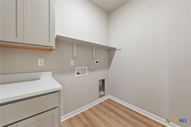 washroom with light hardwood / wood-style floors, electric dryer hookup, cabinets, hookup for a gas dryer, and washer hookup