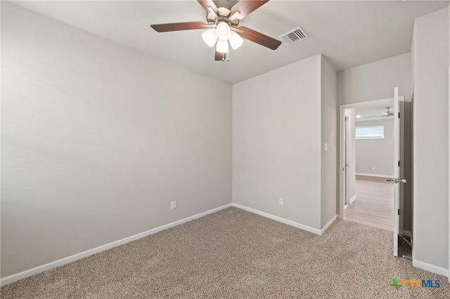 carpeted spare room featuring ceiling fan