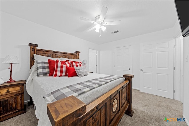 bedroom featuring light carpet, visible vents, and ceiling fan