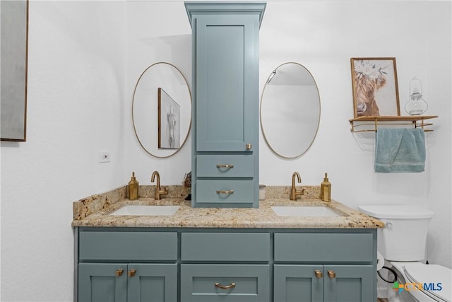 full bath featuring toilet, a sink, and double vanity