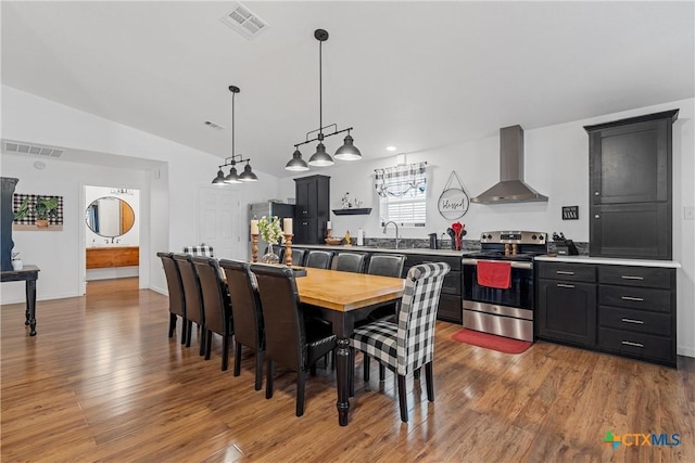 dining room featuring vaulted ceiling, visible vents, and light wood-style flooring