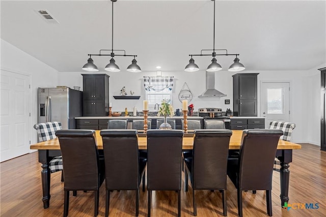 dining room with wood finished floors, visible vents, and a wealth of natural light