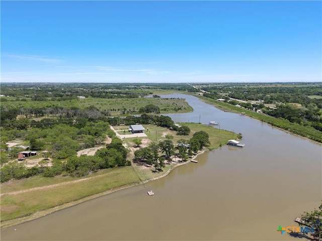 birds eye view of property featuring a forest view and a water view