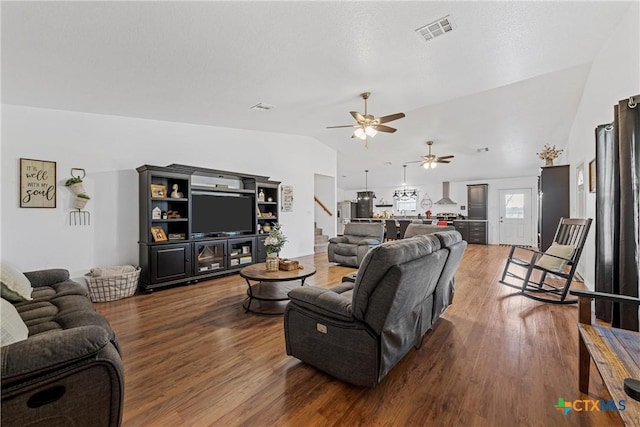 living room with stairway, vaulted ceiling, wood finished floors, ceiling fan, and visible vents