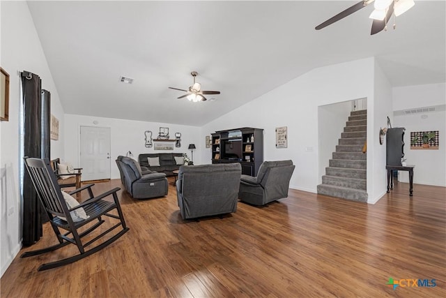 living room with stairway, lofted ceiling, a ceiling fan, and wood finished floors