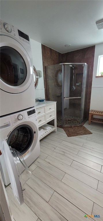 101 E Saint Louis Ave, Seadrift, TX 77983 - laundry area featuring stacked washing machine and dryer and light wood-style flooring