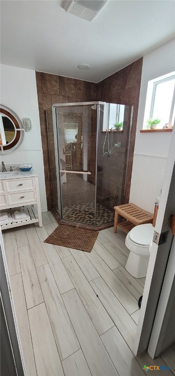 101 E Saint Louis Ave, Seadrift, TX 77983 - full bathroom featuring toilet, a stall shower, wood tiled floors, and vanity