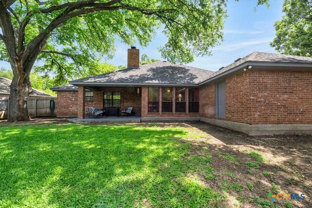 312 Beaver Loop, Temple, TX 76502 - rear view of house featuring a chimney, brick siding, and a patio area