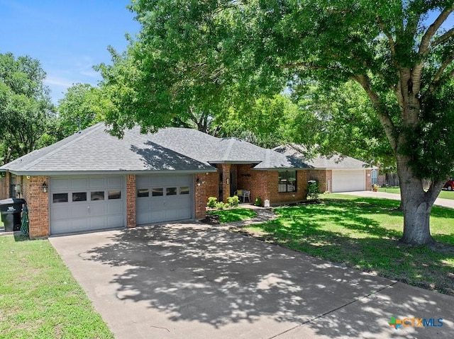 312 Beaver Loop, Temple, TX 76502 - view of front of home with an attached garage, asphalt driveway, a shingled roof, brick siding, and a front yard