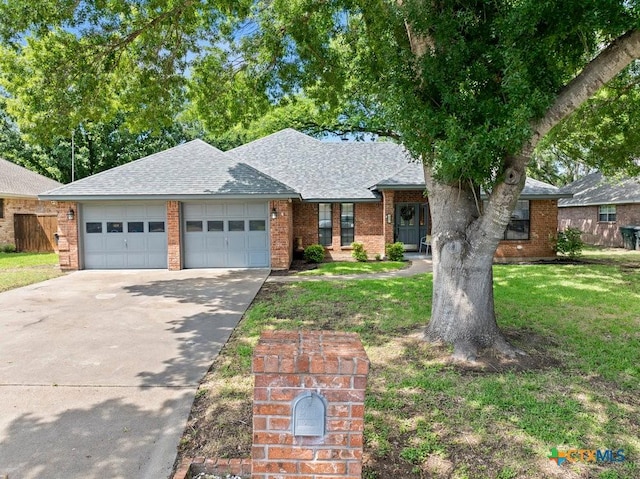 312 Beaver Loop, Temple, TX 76502 - view of front of property with an attached garage, a shingled roof, concrete driveway, a front yard, and brick siding
