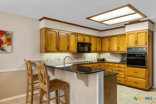 312 Beaver Loop, Temple, TX 76502 - kitchen with black appliances, brown cabinetry, a peninsula, tasteful backsplash, and ornamental molding