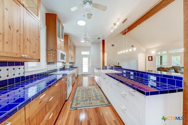 kitchen featuring white appliances, glass insert cabinets, light wood-style floors, vaulted ceiling, and ceiling fan