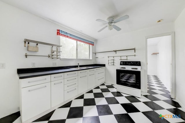 kitchen featuring white electric range oven, a sink, dark floors, ceiling fan, and dark countertops