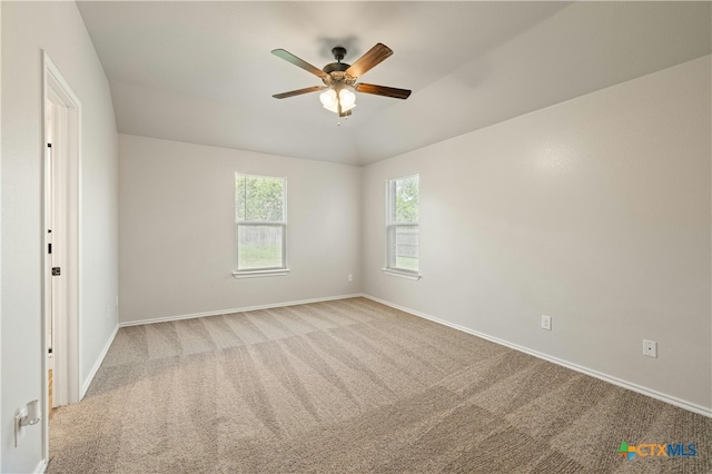 empty room featuring ceiling fan, light carpet, and lofted ceiling