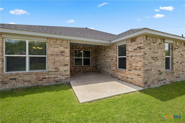 rear view of house featuring a patio and a yard