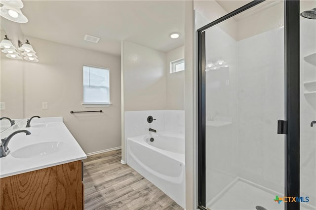 bathroom featuring hardwood / wood-style floors, shower with separate bathtub, and vanity