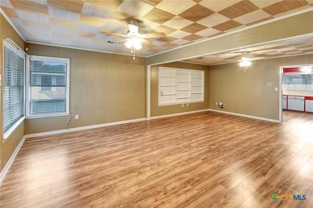 unfurnished room featuring light wood-type flooring, baseboards, ornamental molding, and ceiling fan