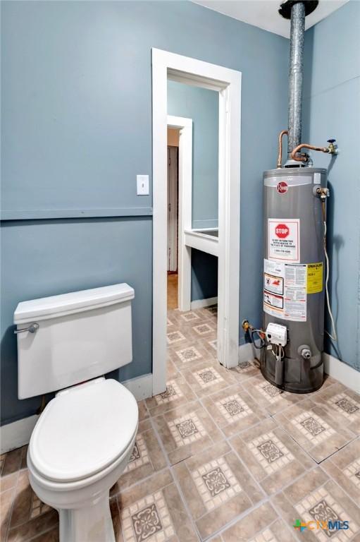 bathroom featuring gas water heater and toilet