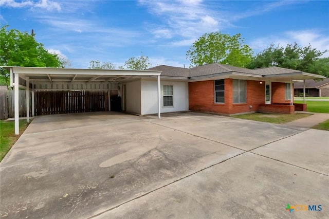 ranch-style house with driveway, a carport, and fence