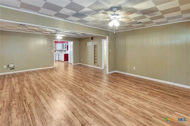 spare room with baseboards, a ceiling fan, visible vents, and light wood-type flooring