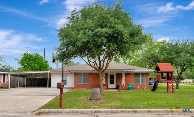ranch-style home featuring a playground, fence, a front lawn, driveway, and a carport