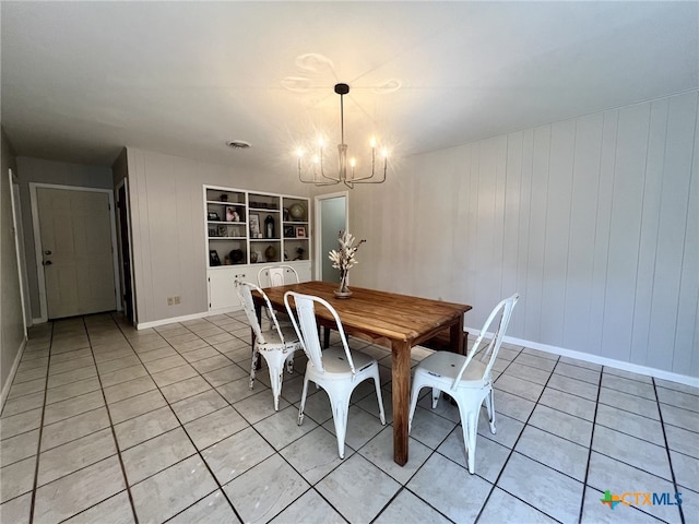 dining room featuring baseboards, built in shelves, a notable chandelier, and light tile patterned flooring