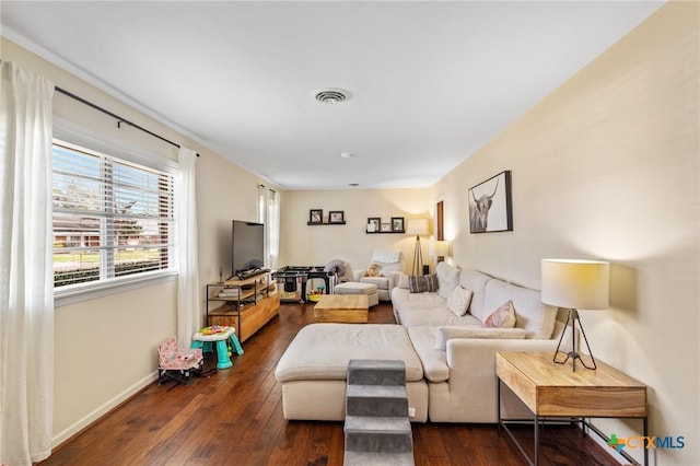 living room with dark wood-type flooring, visible vents, and baseboards