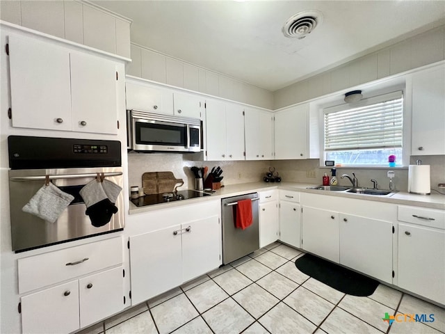 kitchen featuring visible vents, light tile patterned flooring, a sink, stainless steel appliances, and light countertops