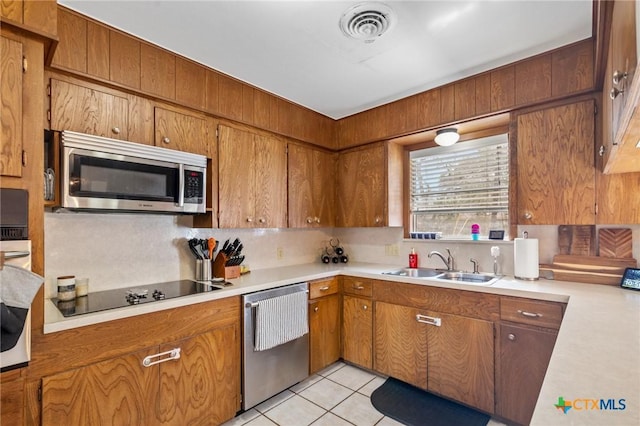 kitchen with light tile patterned floors, a sink, visible vents, light countertops, and appliances with stainless steel finishes